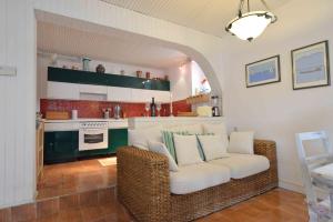 ein Wohnzimmer mit einem weißen Sofa und einer Küche in der Unterkunft Holiday house with WiFi Zlarin - 17998 in Zlarin