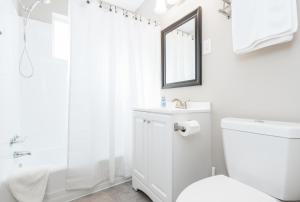 y baño blanco con aseo y ducha. en Stylish OneBedroom in Popular Virginia Highland, en Atlanta