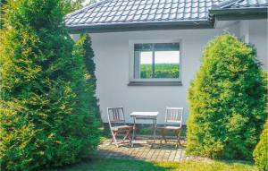 d'une terrasse avec 2 chaises, une table et une fenêtre. dans l'établissement Holiday Home Nowe Warpno Szczecinska, à Karszno