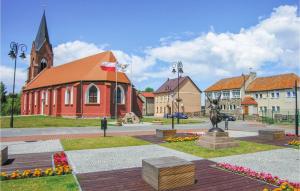 a church with a statue in the middle of a town at Nice Home In Nowe Warpno With 2 Bedrooms And Wifi in Karszno