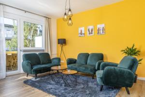 ein Wohnzimmer mit grünen Möbeln und gelben Wänden in der Unterkunft FREE LIVING - Jungle Design Apartments, Zentrum, Parkplatz, Küche, Wlan in Wolfsburg
