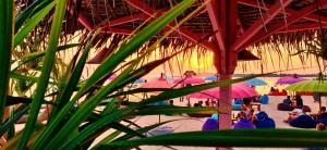 a group of people sitting on a beach with umbrellas at Gili Lumbung Bungalow in Gili Islands