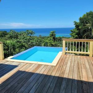 Turquoise view villa with pool! في رواتان: حمام سباحة على سطح مع المحيط في الخلفية