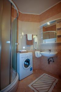 een badkamer met een wasmachine en een wastafel bij Family friendly apartments with a swimming pool Nevidjane, Pasman - 18054 in Neviđane