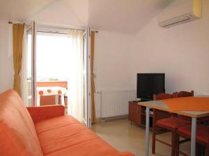 sala de estar con sofá, mesa y TV en Family friendly apartments with a swimming pool Nevidjane, Pasman - 18054 en Neviđane