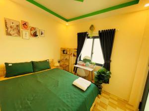 een slaapkamer met een groen bed en een raam bij Duy Cảnh Homestay in Con Dao