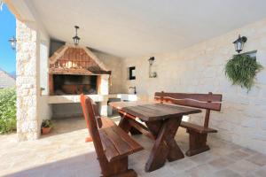 d'une terrasse avec une table et des bancs en bois ainsi qu'une cheminée. dans l'établissement Holiday house with a parking space Zivogisce - Strnj - Zivogosce - Strnj, Makarska - 18025, à Živogošće