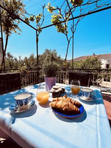 una mesa con un paño de mesa azul con comida y zumo de naranja en Apartments and rooms with parking space Makarska - 18028 en Makarska