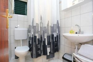 a bathroom with a toilet and a city shower curtain at Apartments and rooms with parking space Makarska - 18028 in Makarska
