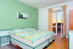 a bedroom with a bed in a room with a window at Apartments and rooms with parking space Makarska - 18028 in Makarska