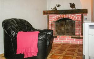 a black leather chair with a pink blanket on a fireplace at Cozy Home In Gdynia With Wifi in Gdynia