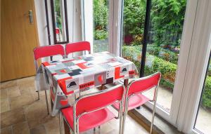 a table with four red chairs in front of a window at Cozy Home In Gdynia With Wifi in Gdynia