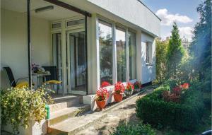 a house with potted flowers on the steps of it at Cozy Home In Gdynia With Wifi in Gdynia +20 photos