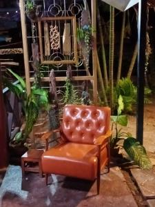 einem braunen Ledersessel in einem Zimmer mit Pflanzen in der Unterkunft Cozy Garden Resort in Ao Nang Beach