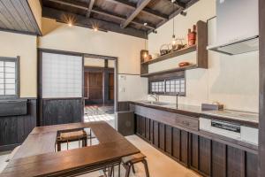 a kitchen with a wooden table and wooden counters at 農家体験民宿 古民家 薄衣 in Ichinoseki