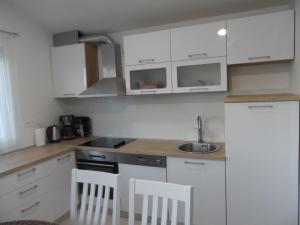 una cocina con armarios blancos y fregadero en Apartments with a parking space Opuzen, Neretva Delta - Usce Neretve - 18070, en Opuzen