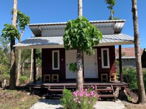 a small house with a porch and a tree at Rinjani Garden by ecommerceloka in Sembalun Lawang