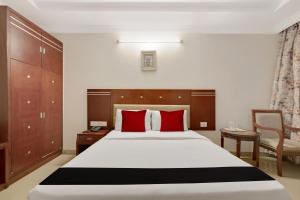 una camera da letto con un grande letto con cuscini rossi di Elegant Amethyst Business Hotel Near Ragigudda Sri Prasanna a Bangalore