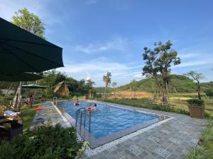 a swimming pool with people in the water at OMTARA RETREAT in Yen Bai