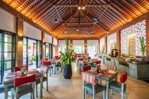 a restaurant with tables and chairs and a counter at Kuta Seaview Boutique Resort in Kuta
