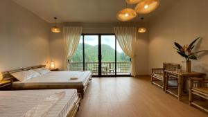 a large bedroom with two beds and a balcony at OMTARA RETREAT in Yen Bai