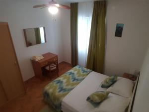 - une chambre avec un lit, un bureau et un miroir dans l'établissement Apartments and rooms with parking space Makarska - 18106, à Makarska