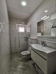 La salle de bains blanche est pourvue de toilettes et d'un lavabo. dans l'établissement Apartments and rooms with parking space Makarska - 18106, à Makarska