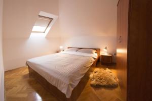 a bedroom with a bed with a window and a rug at Apartments for families with children Otocac, Velebit - 18109 in Otočac