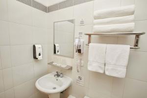 a bathroom with a sink and a mirror and towels at Casa Andina Standard Puno in Puno