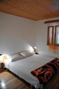 a bedroom with a white bed with a wooden ceiling at Apartments by the sea Ivan Dolac, Hvar - 18100 in Jelsa
