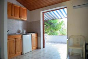 a kitchen with a white refrigerator and a sliding glass door at Apartments by the sea Ivan Dolac, Hvar - 18100 in Jelsa +26 photos