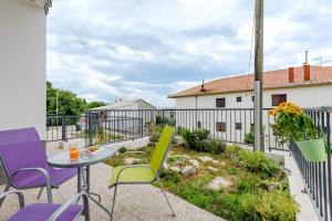 eine Terrasse mit bunten Stühlen und einem Tisch in der Unterkunft Apartments with a parking space Solin, Split - 18064 in Solin