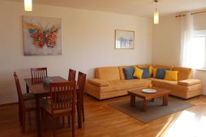 a living room with a couch and a table at Family friendly apartments with a swimming pool Kozino, Zadar - 18121 in Kožino