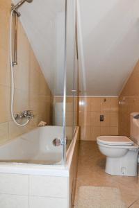 a bathroom with a bath tub and a toilet at Family friendly apartments with a swimming pool Kozino, Zadar - 18121 in Kožino