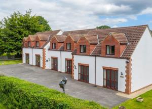 una casa grande con muchas ventanas en White Rose Country Cottages en Thormanby