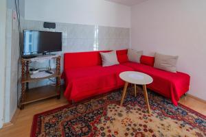 a living room with a red couch and a table at Apartments with parking space Slunj, Plitvice - 18152 in Slunj
