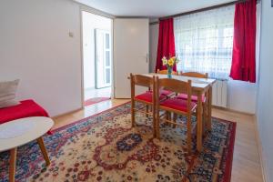 a living room with a table and chairs and a red couch at Apartments with parking space Slunj, Plitvice - 18152 in Slunj