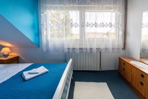 Apartments with a parking space Slunj, Plitvice - 18152 في سلوني: غرفة نوم بسرير ازرق ونافذة