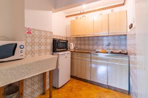 Apartments with a parking space Slunj, Plitvice - 18152 في سلوني: مطبخ مع ميكروويف وقمة كونتر