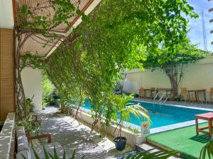 einen Pool mit einem Tisch und Stühlen neben einem Gebäude in der Unterkunft Rehendhi Villa in Maafushi