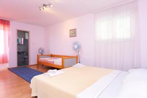 een witte slaapkamer met een bed en een raam bij Apartments with a parking space Makarska - 18145 in Makarska