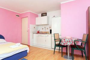 een kamer met een tafel en stoelen en een keuken bij Apartments with a parking space Makarska - 18145 in Makarska