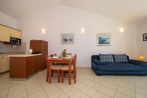 a living room with a blue couch and a table at Apartments by the sea Igrane, Makarska - 18069 in Igrane
