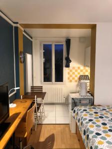 sypialnia z łóżkiem, biurkiem i stołem w obiekcie Studio avec panorama sur la ville basse du Havre w Hawrze