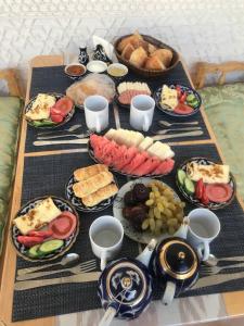 une table avec des assiettes de nourriture sur une table dans l'établissement ESHONI PIR Boutique HOTEL, à Boukhara