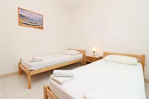 a room with two beds and a picture on the wall at Apartments by the sea Prizba, Korcula - 18165 in Prizba