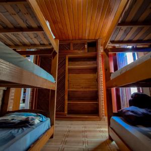Pokój z 2 łóżkami piętrowymi i drzwiami w obiekcie Efferus Hostel w mieście Ubatuba