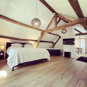 ein Schlafzimmer mit einem großen Bett und Holzböden in der Unterkunft Hoeve Berghof in Heerlen