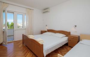 a bedroom with a bed and a large window at Apartments and rooms by the sea Duce, Omis - 18155 in Omiš