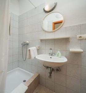 a bathroom with a sink and a tub and a mirror at Apartments and rooms by the sea Duce, Omis - 18155 in Omiš